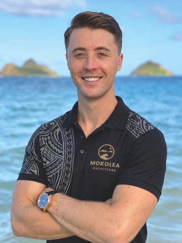 James Jenkins, owner of Mokolea Outfitters, at Lanikai with the Mokulua islands behind him